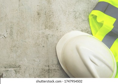 white hard safety helmet hat for safety project of workman as engineer or worker, on concrete floor. Standard construction safety equipment.
