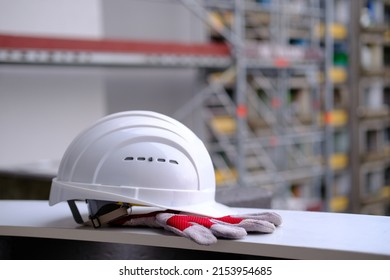 white hardhat, work gloves, helmet on background of buildings, protection inspecting at construction site, symbol of builder's death, day of mourning, civil engineering concept, builder's day