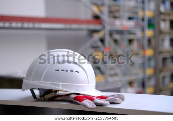white
hardhat, work gloves, helmet on background of buildings, protection
inspecting at construction site, symbol of builder's death, day of
mourning, civil engineering concept, builder's
day