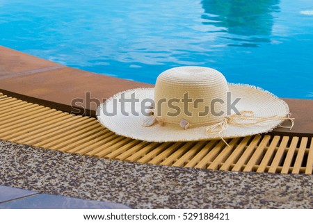 White hat on the ground nearby the brink of pool.