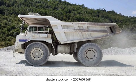 white Haul truck in the quarry, big and large articulated dumping truck, dumper trailer, dump lorry. off-highway heavy-duty construction environment with two axle.