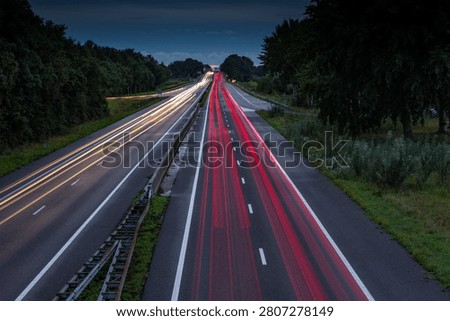 White headlights and red tail lights on a evening on the A44 highway near the village of Sassenheim in the province of South Holland in the Netherlands. Long exposure picture.