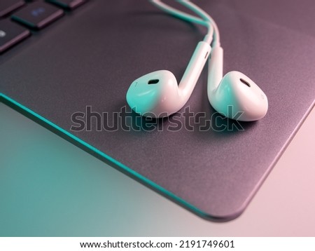 White headphones with a cable on a laptop. Close-up.