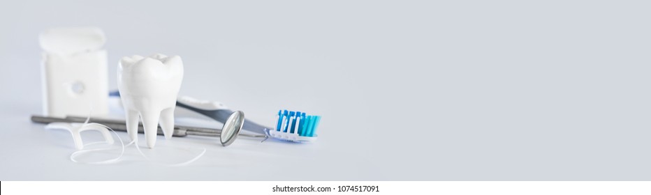 White healthy tooth, different tools for dental care. Dental background. - Shutterstock ID 1074517091
