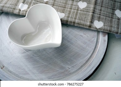 White heart shaped dish on a wooden tray