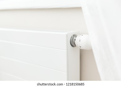 White heating radiator with a thermostat in room at home. - Shutterstock ID 1218150685