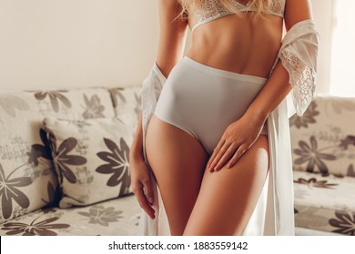 White High-waist Panties On Sportive Booty And Bra. Slim Woman Wearing Sexy Lace Underwear And Dressing Gown At Home. Healthy Young Female Body