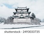 White Hirosaki Castle or Takaoka Castle with snow in winter, hirayama style Japanese castle located in Hirosaki city, Aomori Prefecture, Tohoku, Japan. Landmark for tourist attraction. Japan travel