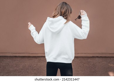 White Hoodie On A Young Woman, Back View, Mockup. Lifestyle.