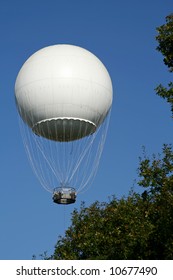 White Hot Air Ballon In The Air Above The Trees