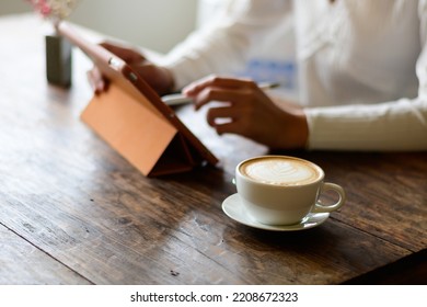 White Hot Coffee A Woman In A White Shirt Works An Orange IPad At A Coffee Shop In Chiang Mai On 29.9.2022.