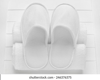 White Hotel / Home/ Spa / Wellness Slippers With Rolled Towels On Light Wooden Desk - Summer Sauna Time