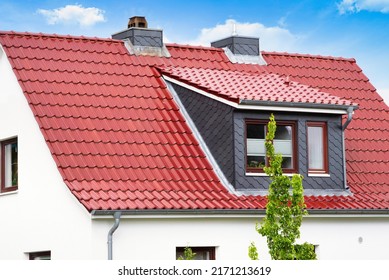 White house with red roof tiles and dormer with dark gray shingles