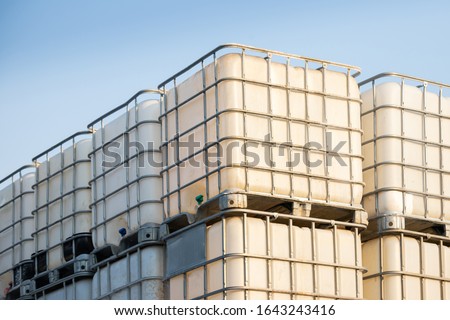 white ibc container in outdoor stock yard of factory, white plastic chemical tanks