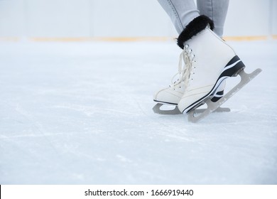 White Ice Skates Is On Woman's Legs On The Rink Close Up