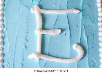 White Icing Letter E On A Blue Cake (series Spells LOVE)