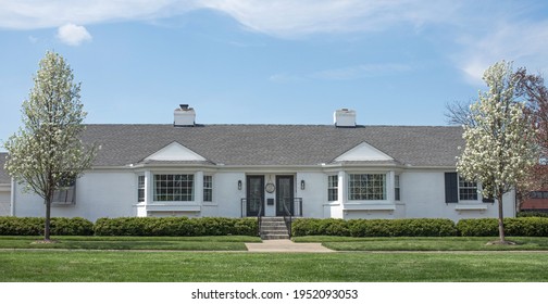 White Identical Duplex In Spring With Flowering Pear Trees