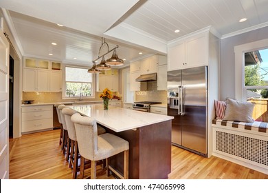 White Interior Of Kitchen Room With Bar Style Kitchen Island And Stools, Stainless Steel Double Fridge And View Of Window Seat. Northwest, USA