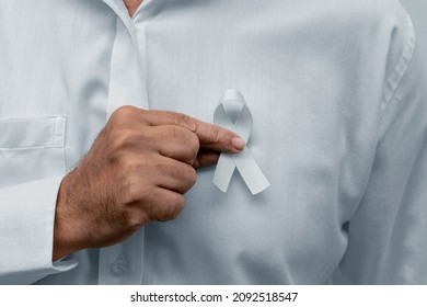 White January, mental health awareness campaign. Man holding a white ribbon. - Powered by Shutterstock