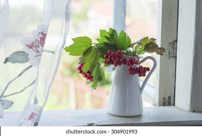 White Jar With Branches Of Viburnum Stands At The Window. Still Life With A Snowball In A Country House.