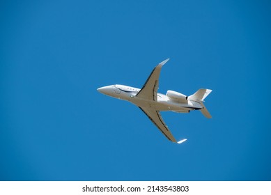 White Jet Airplane Taking Off Overhead Blue Sky