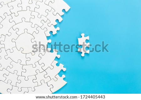 White jigsaw puzzle pieces on a blue background. Problem solving concepts. Texture photo with copy space for text
