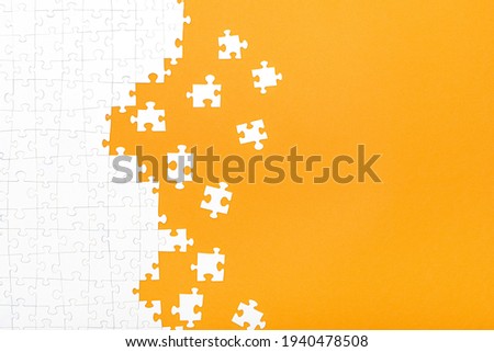 White jigsaw puzzle pieces on orange background copy space for your text. Business concept. 