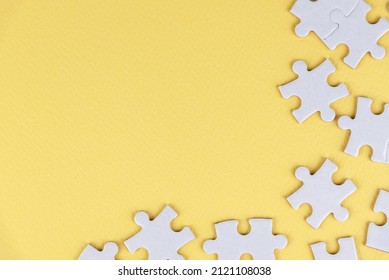 White jigsaw puzzle with some missing pieces on blank soft yellow background. Blank missing puzzle piece for your creative text idea. Blank white and yellow jigsaw puzzle backgrounds.