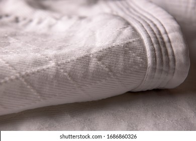 White judo uniform detail. Diamond stitchied fabric - Powered by Shutterstock