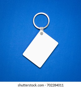 White Key Ring On Blue Background. Key Chain For Your Design. Hanging Accessory Or Souvenir. ( Rectangle Shape )