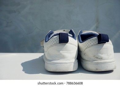White kid shoes on grey textured background


