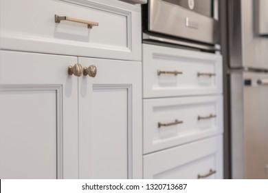 White Kitchen Built With Shaker Style Cabinets. Shows Cabinet Details And Brushed Gold Hardware Knobs And Pulls