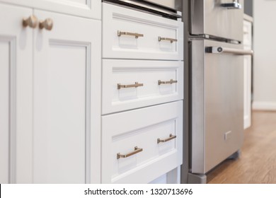 White Kitchen Built With Shaker Style Cabinets. Shows Cabinet Details And Brushed Gold Hardware Knobs And Pulls