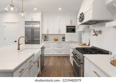 White Kitchen Detail In New Luxury Home: Includes Oven, Range,Stainless Steel Refrigerator, Hood, Cabinets, And Countertop