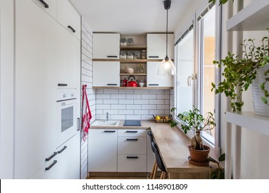 White kitchen with red components, cosy tiny home after the reconstruction in panel house