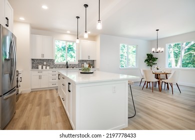 White Kitchen With Stools Tile Backsplash Chefs Island Stainless Appliances Wood Floor