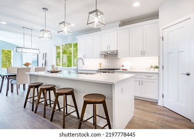 White Kitchen With Stools Tile Backsplash Chefs Island Stainless Appliances Wood Floor