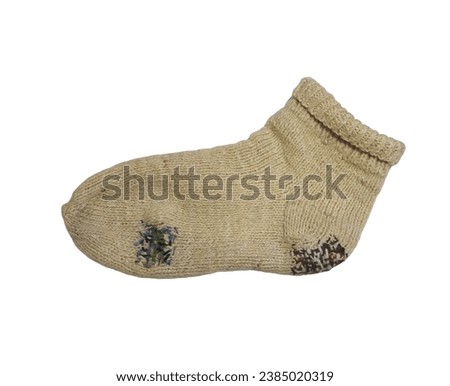      White knitted wool sock darned with colored threads. The item is isolated on a white background.     