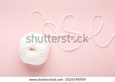 White knitting wool on pastel pink background. Hobby knitting. Top view - Image