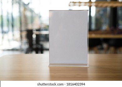 White Label In Cafe. Display Stand For Acrylic Tent Card In Coffee Shop. Mockup Menu Frame On Table In Bar Restaurant. Space For Text