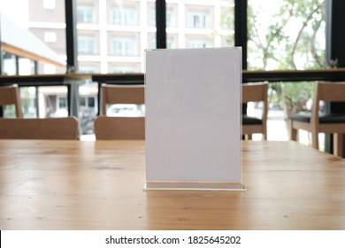 White Label In Cafe. Display Stand For Acrylic Tent Card In Coffee Shop. Mockup Menu Frame On Table In Bar Restaurant. Space For Text