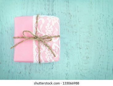 White lace and a simple bow on pink gift box on light blue wooden vintage background - concept for a girl's birthday or for mother's day - Powered by Shutterstock