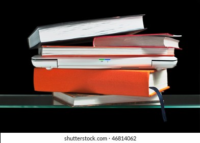 White Laptop Computer Between Books On The Glass Shelf