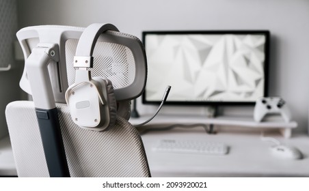 White Large Gaming Headphones With A Microphone Hang On A White Armchair. Close-up