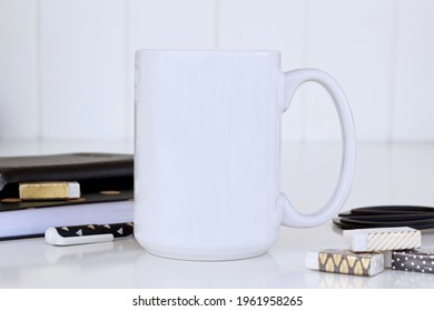 White Large Mug Mockup On Work Desk With Notebooks, Gold Erasers And Pencil. 15 Oz Mug Mock Up