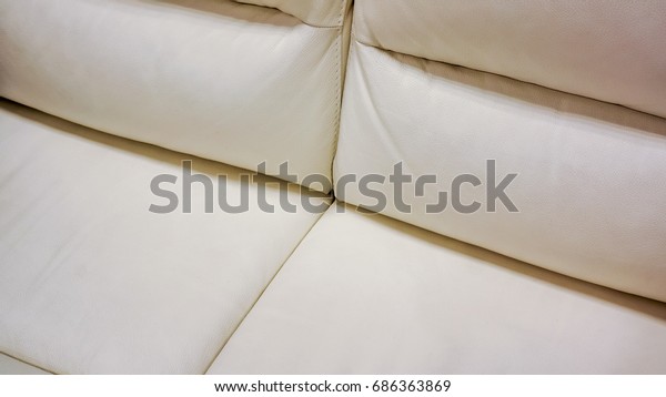 white lather soft sofa\
divided into two vertical sections for comfortable waiting on\
reception or in waiting room in big office. close up of white sofa\
in a waiting room