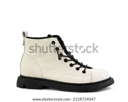 White leather ankle boots with black laces and black rubber sole. Isolated close-up on white background. Right side view. Casual seasonal shoes. Fashion shoes