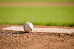 A White Leather Baseball Lying On Top Of The Pitcher's Mound At A Baseball Field With Copy Space