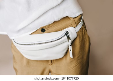 White Leather Fanny Pack, Cell Phone Belt Pouch. Selective Focus. Blurred Background.