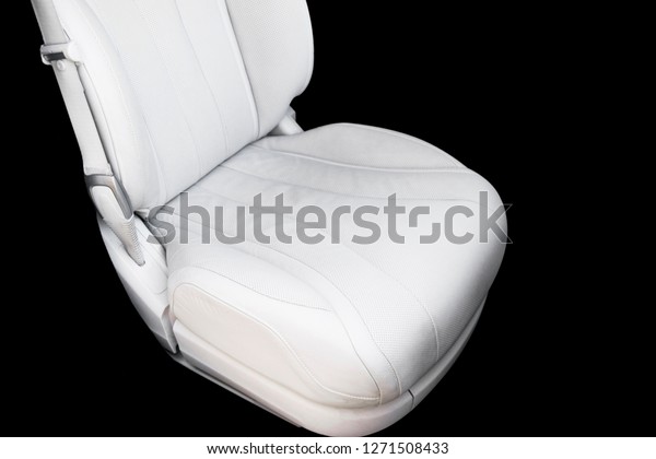 White leather interior of the luxury modern\
car. Perforated Leather comfortable white seats with stitching\
isolated on black background. Modern car interior details. Car\
detailing